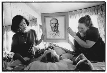 Betty on the bed, with Akaisha and Karena holding a sketch of their Father so Betty can see him