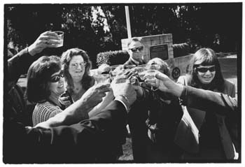 Close family and friends at the gravesite, toasting with champagne