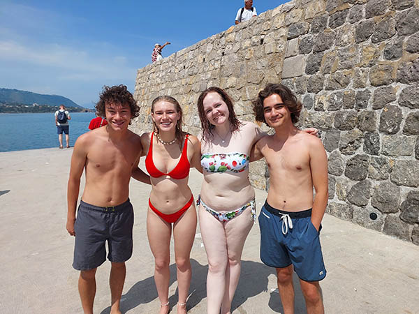 4 language students at the end of a pier type structure, Cefalu, Sicily