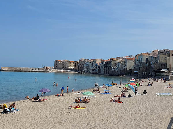 Beach goers on Poseidon Beach, Cefalu, Sicily