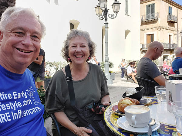 Happy older couple having capuccino and croissant, Cefalu, Sicily