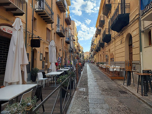 Side street showing outdoor seating of restaurants, Cefalu, Sicily