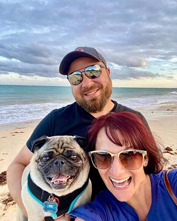 Man and woman with their dog on the beach