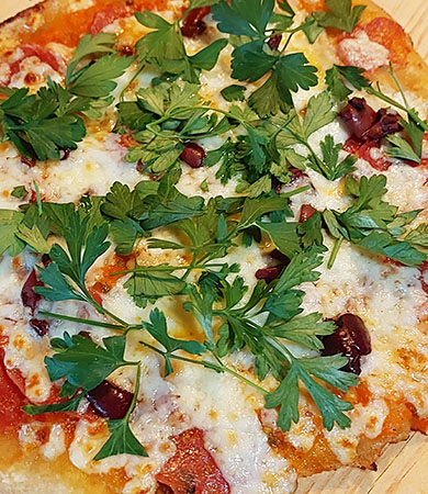 Another one of our grilled Biga dough pizzas with kalamata olives, various cheeses, fresh herbs and home made pizza sauce