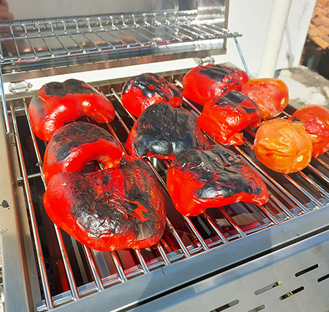 Blistering red bell peppers and fresh tomatoes on our gas grill