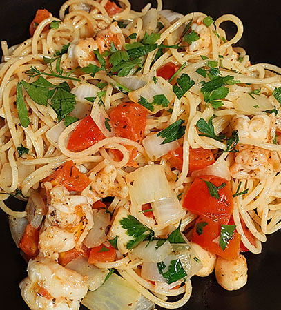 Marinated and grilled shrimp with pasta, fresh herbs, sautéed onions, garlic and cracked pepper