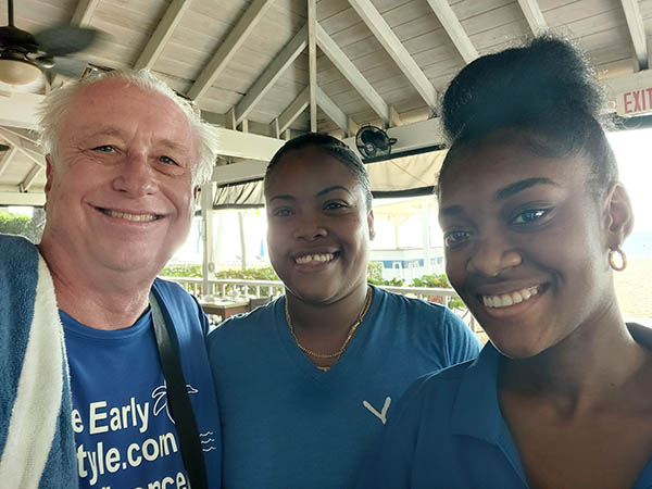 Senior man with 2 barmaids at Hamilton Beach Villas and Spa, Nevis, West Indies