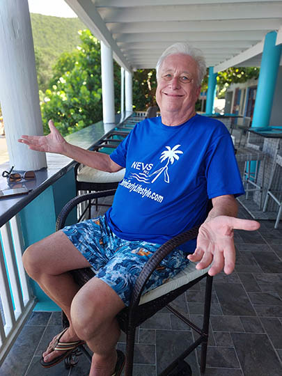 Senior man sitting on a chair overlooking the sea at On The Rocks Bar and Lounge, Nevis, West Indies