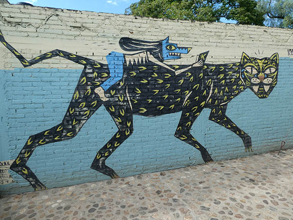 Masked human riding a large wild cat, Street art of Oaxaca City, Mexico