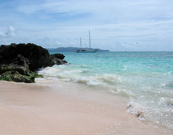 Perfect beach, gentle waves, sailboat in the water, Mexico