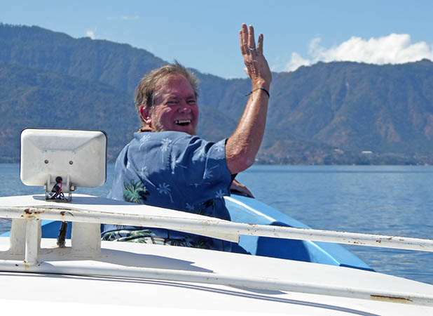Greg waves from the bow of the lancha