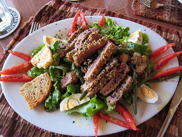 A salad with seared Ahi tuna encrusted with sesame seeds