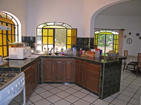 Bright kitchen area with dining room to the right.