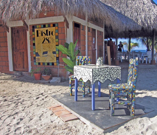Mosaic tiled table and chairs beckon for customers to come in to this little seaside bistro. Zicatela, Puerto Escondido, Mexico