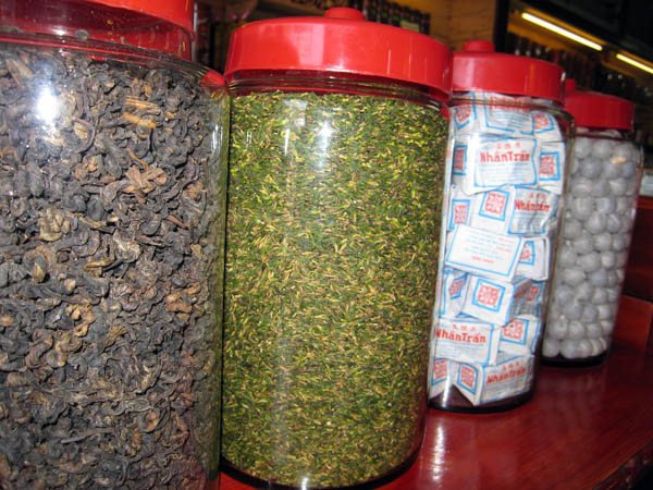 Large jars of tea including tea balls in the last jar